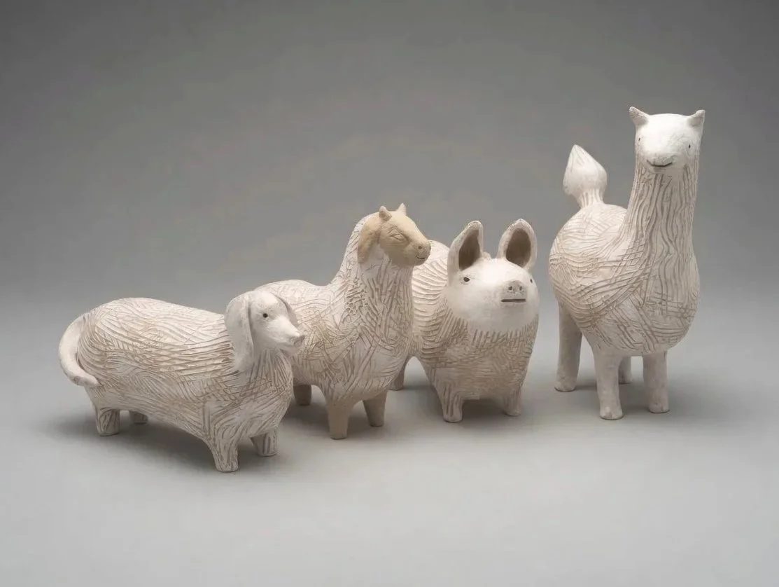 Four ceramic animal vessels — dog, goat, pig, and llama — decorated with incised line patterns.